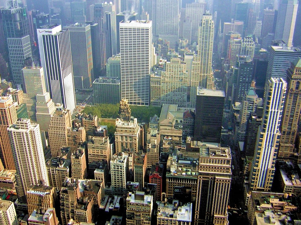 Vista panorámica de Manhattan desde el mirador del Empire State Building, con el trazado de avenidas y los rascacielos extendiéndose hacia el horizonte bajo un cielo despejado.