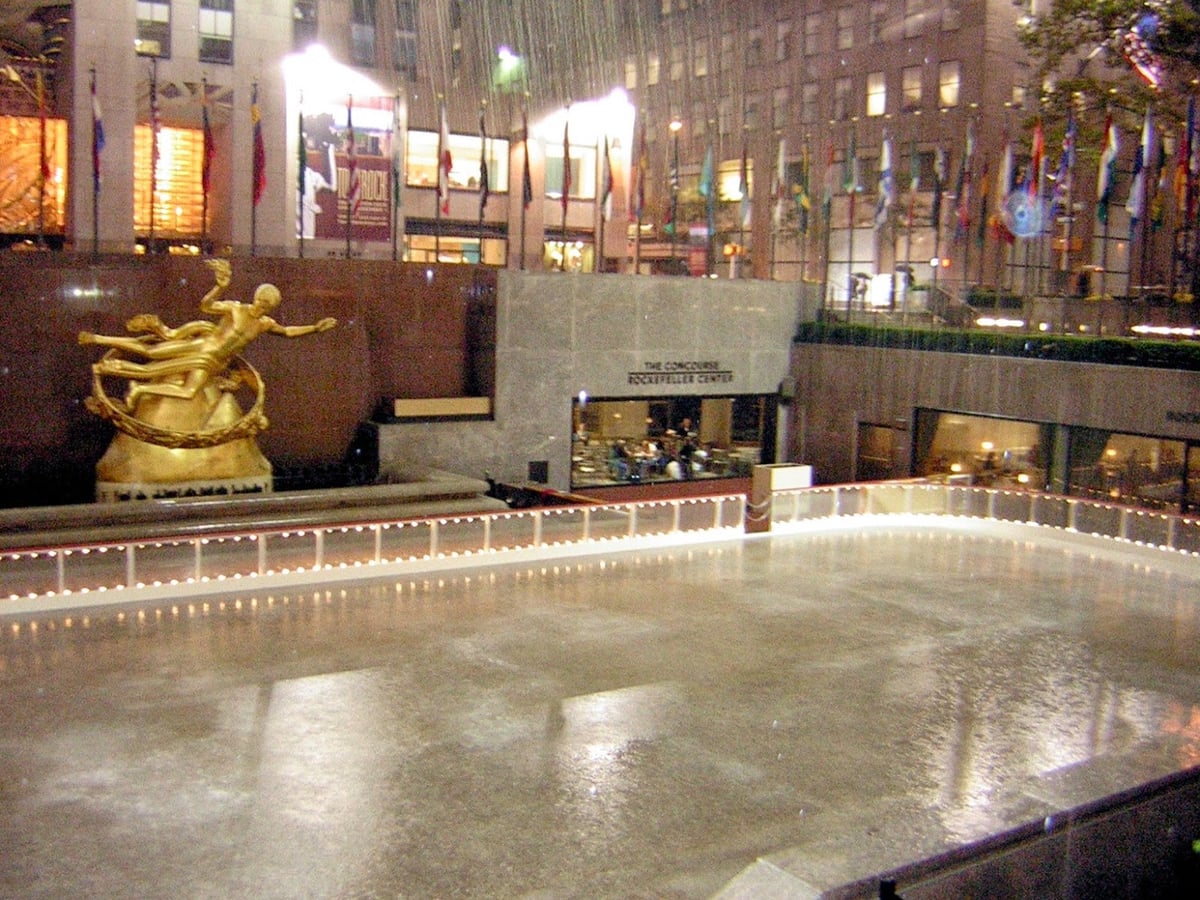 La pista de patinaje sobre hielo delante del Rockefeller Center, con la estatua dorada de Prometeo al fondo y las banderas de distintos países en el perímetro.