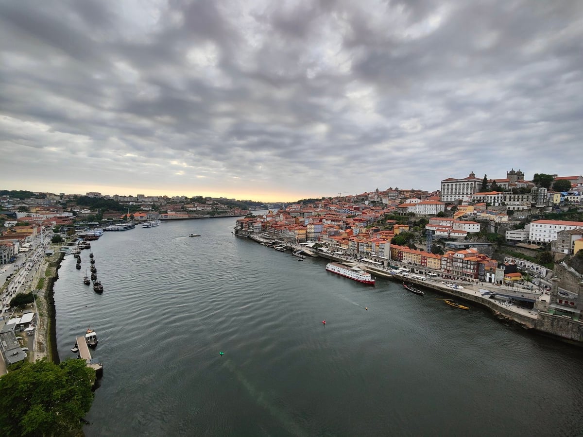 El Duero a su paso por Oporto al atardecer, con el puente Luis I a la izquierda, las bodegas de Vila Nova de Gaia en la orilla sur y el casco histórico subiendo por la ladera opuesta.