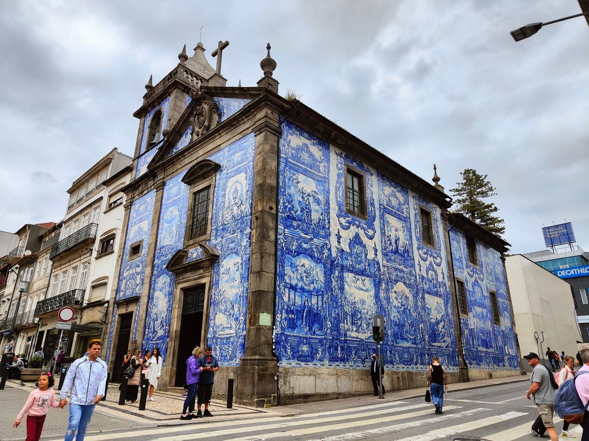 Fachada de la Capela das Almas de Oporto completamente revestida de azulejos azules y blancos con escenas de la vida de los santos.
