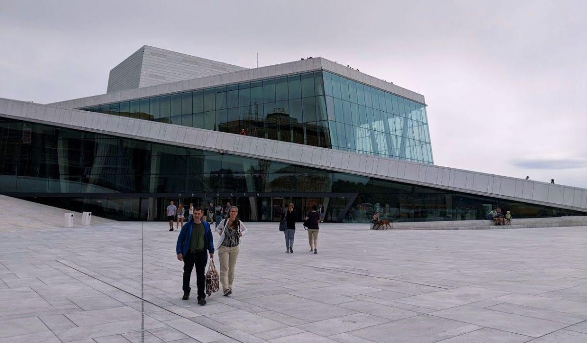 La cubierta inclinada de mármol blanco de la Ópera de Oslo, con gente paseando por ella