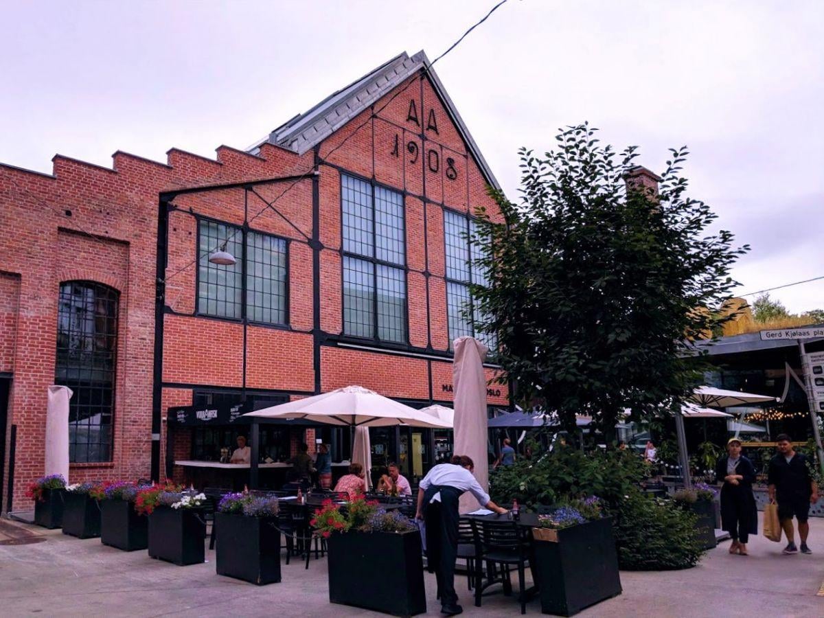 La fachada de ladrillo del mercado de Vulkan, con las terrazas de los restaurantes en la calle