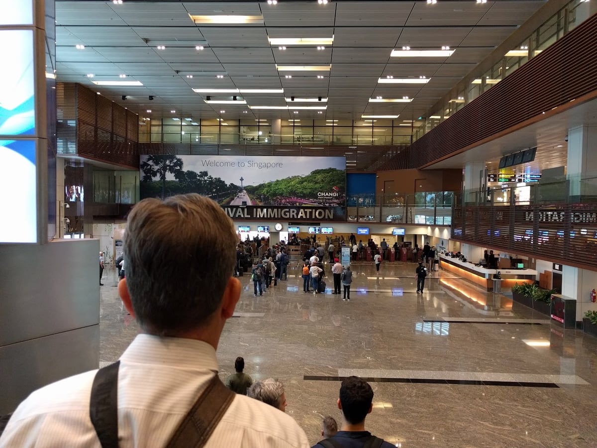 Vista nocturna de Marina Bay en Singapur con edificios iluminados y reflejos en el agua