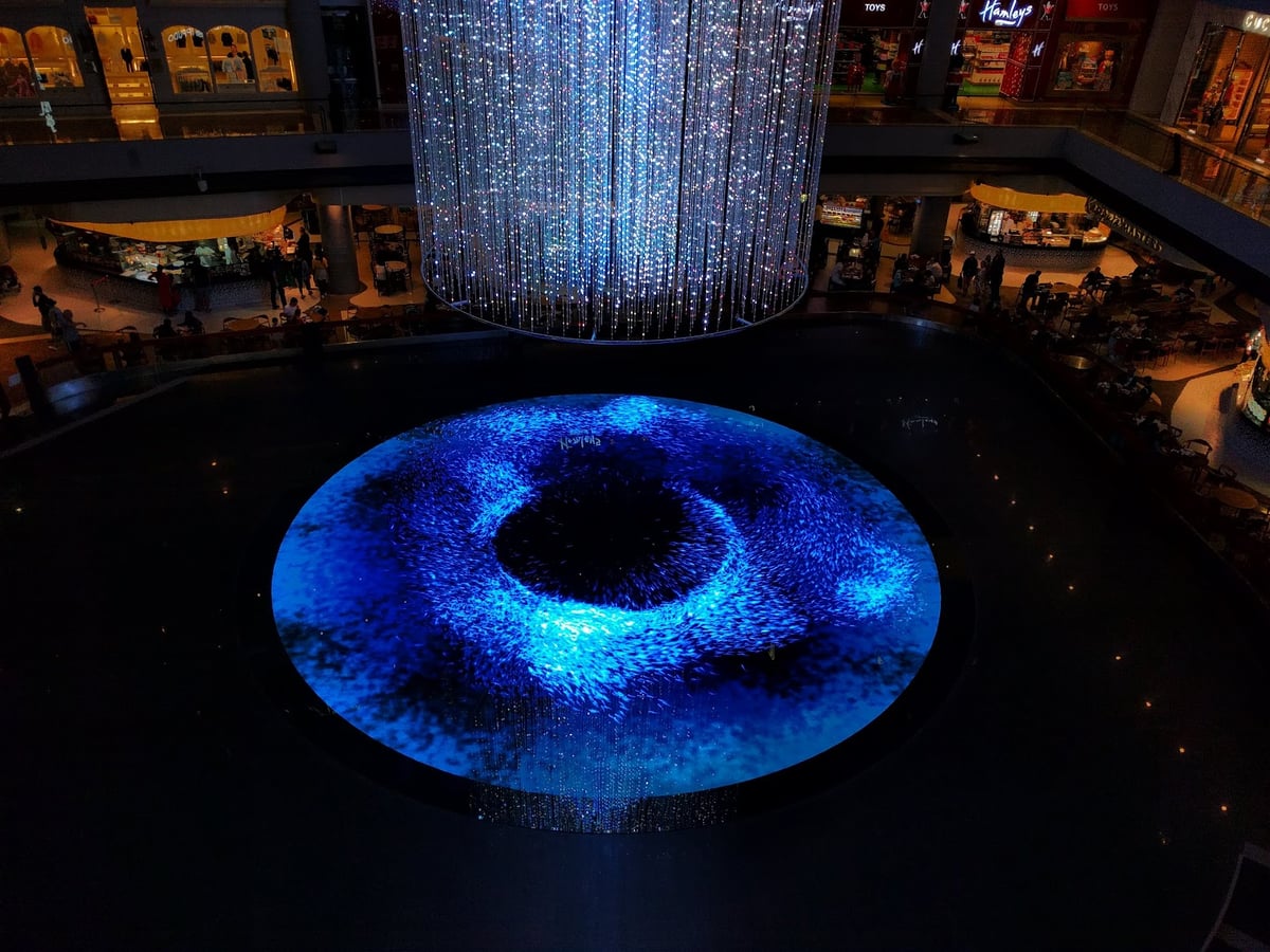 Vista nocturna de Marina Bay en Singapur con edificios iluminados y reflejos en el agua