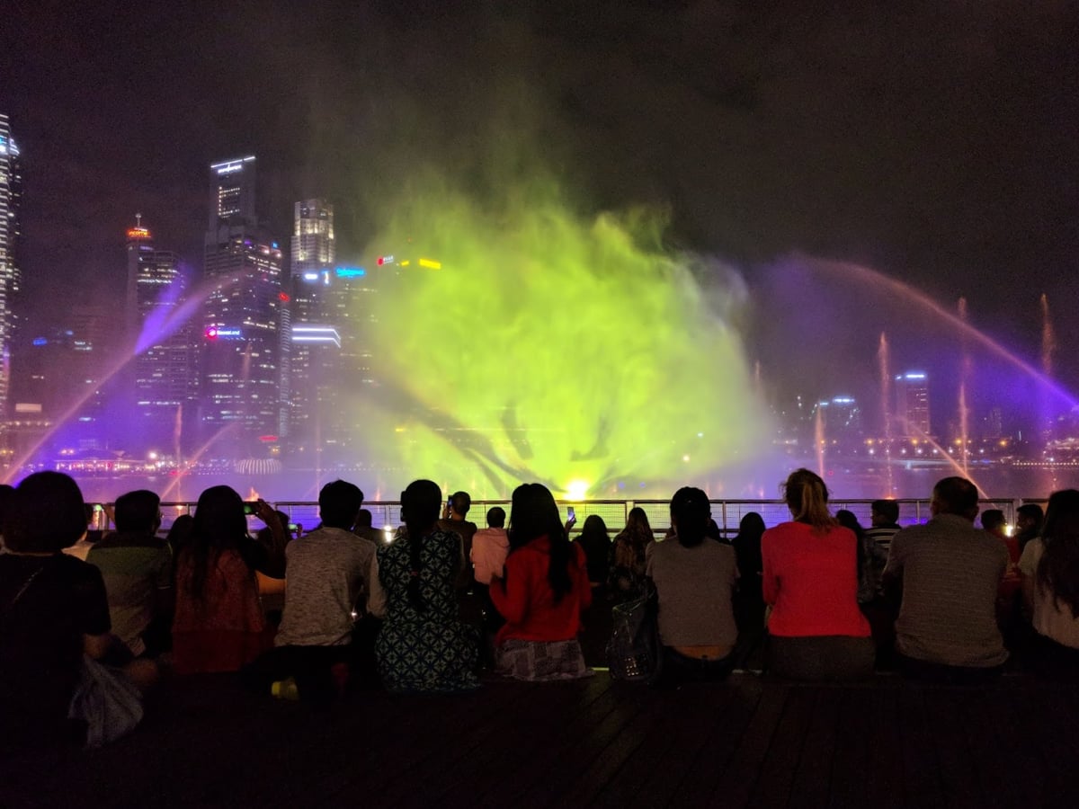 Vista nocturna de Marina Bay en Singapur con edificios iluminados y reflejos en el agua