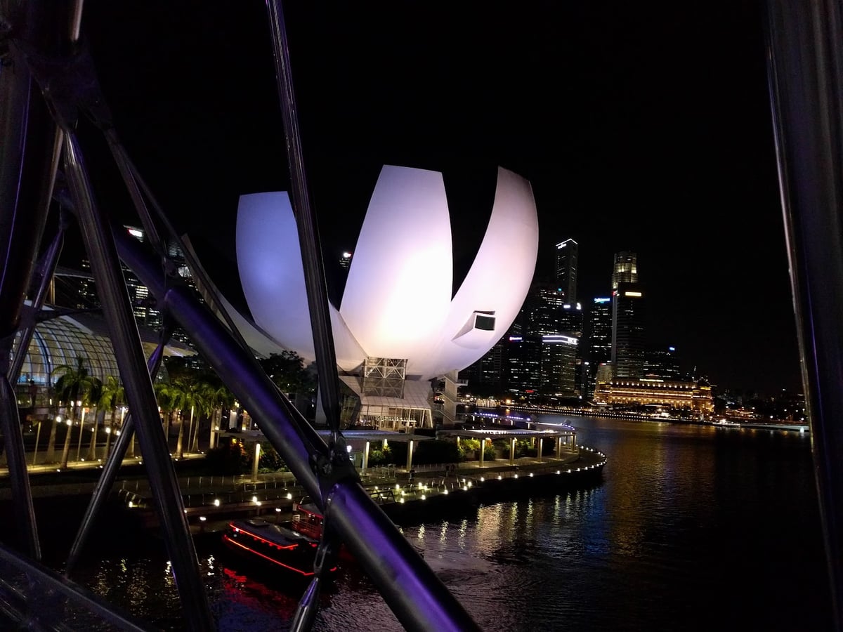 Vista nocturna de Marina Bay en Singapur con edificios iluminados y reflejos en el agua