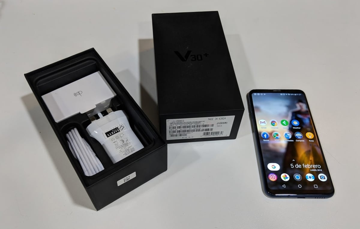Teléfono móvil mostrado junto a su caja y accesorios