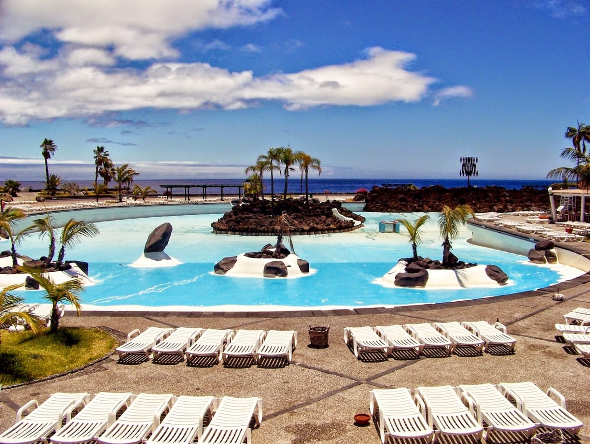 Complejo turístico junto al mar en Tenerife con piscinas y jardines