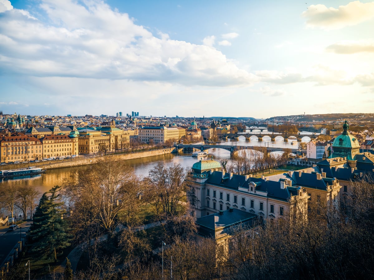 Una hermosa vista aérea de Praga que muestra sus emblemáticos puentes y el río al atardecer.