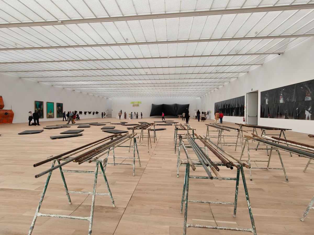 Gran sala superior de Agravitas con suelo de tarima clara, techo de lucernarios y caballetes con tubos metálicos como instalación