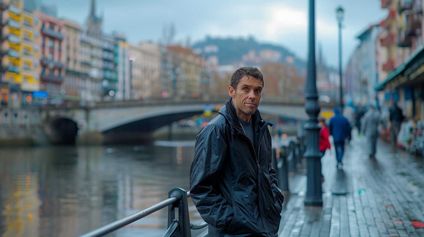 Un hombre de mediana edad sentado solo en una terraza del Casco Viejo de Bilbao, con un periódico desplegado sobre la mesa. La imagen tiene una calidad ligeramente onírica, como si el reflejo en el cristal del bar no terminara de coincidir con la realidad.
